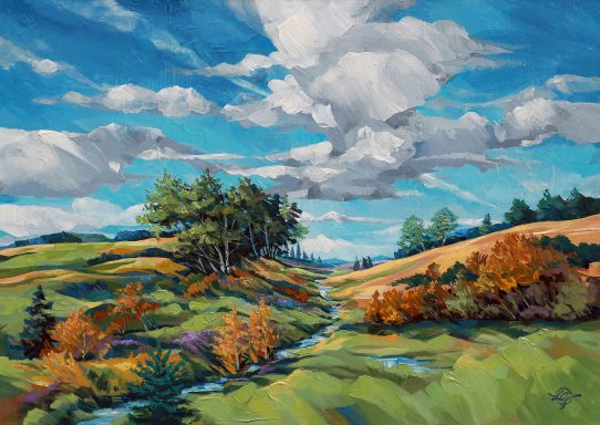Landschaft im Spätsommer mit sanften Hügeln, Bäumen, bunten Sträuchern und einem blauen Himmel. late summer day 