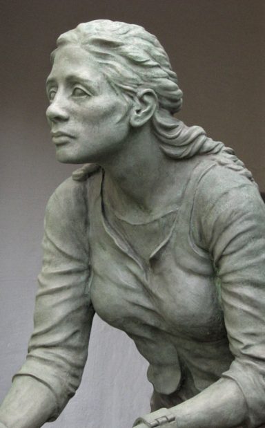 Eine Skulptur einer Frau mit langen Haaren und sanftem Ausdruck.